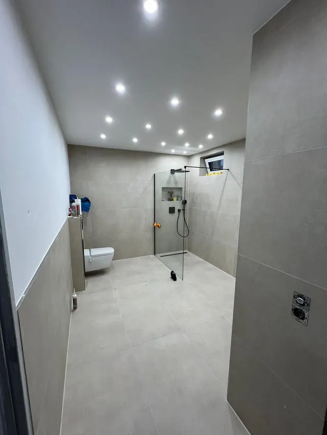 Fertiges Bad mit bodengleicher Walk-in-Dusche, Glaswand und LED-Einbauspots